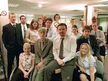 The cast of The Office posed as an office team photograph, with David Brent seated at the centre.