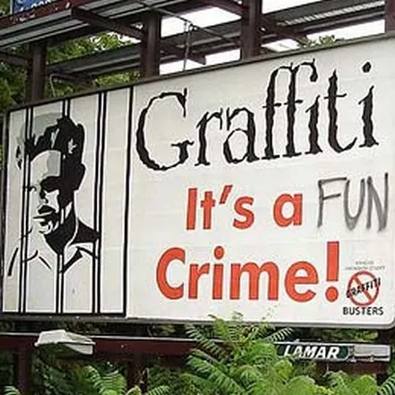 A billboard reading “Graffiti: it’s a fun crime!” with the word “fun” crossed through by an anti-graffiti campaign sticker.